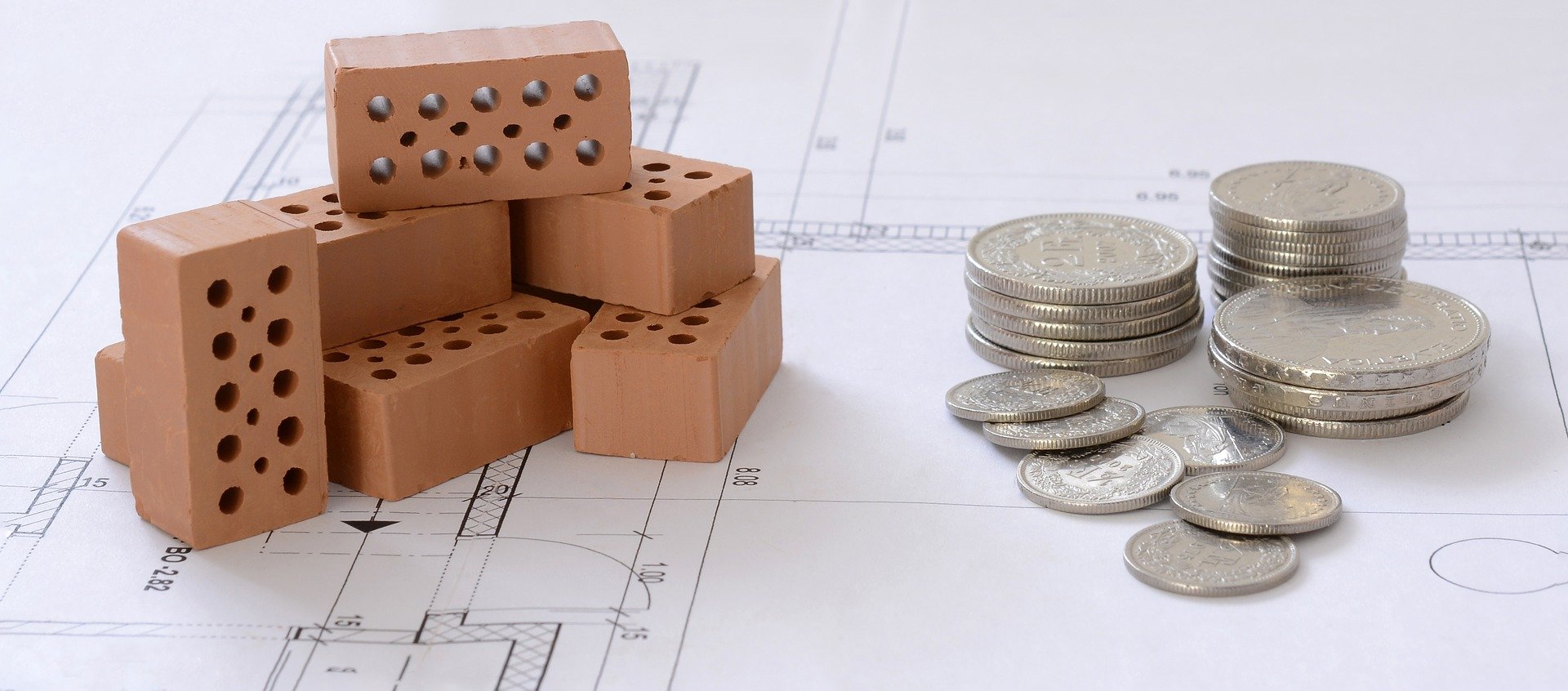 Baufinanzierung (Bauplan, Bauklötze und Euro-Münzen)