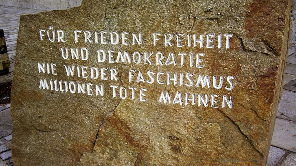 Mahnstein vor dem Geburtshaus Adolf Hitlers. "Für Frieden Freiheit und Demokratie nie wieder Faschismus Millionen Tote Mahnen"