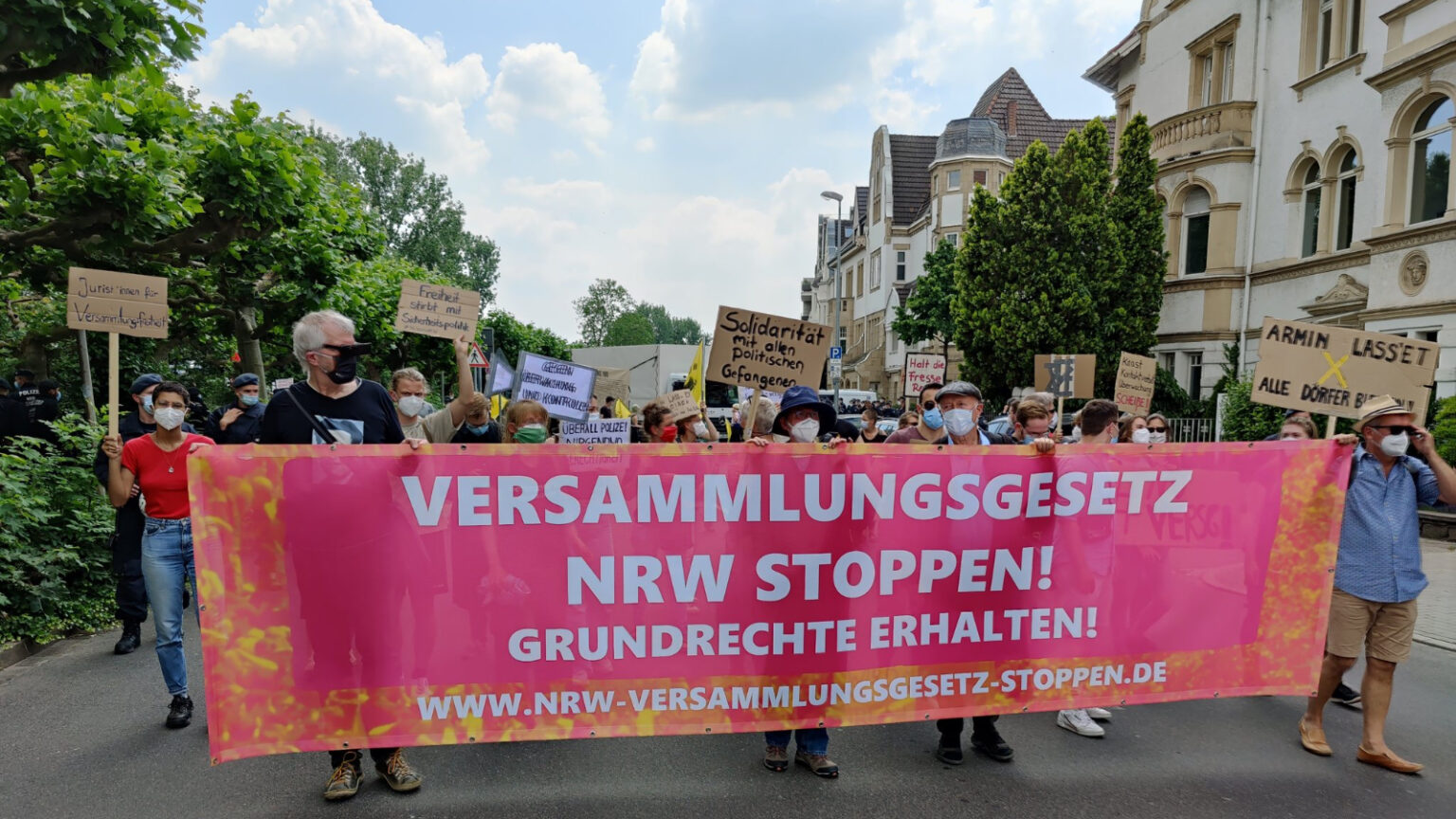 Bild einer Demonstration gegen das Versammlungsgesetz NRW. Banner mit der Aufschrift "Versammlungsgesetz NRW stoppen! Grundrechte erhalten! www.nrw-versammlungsgesetz-stoppen.de