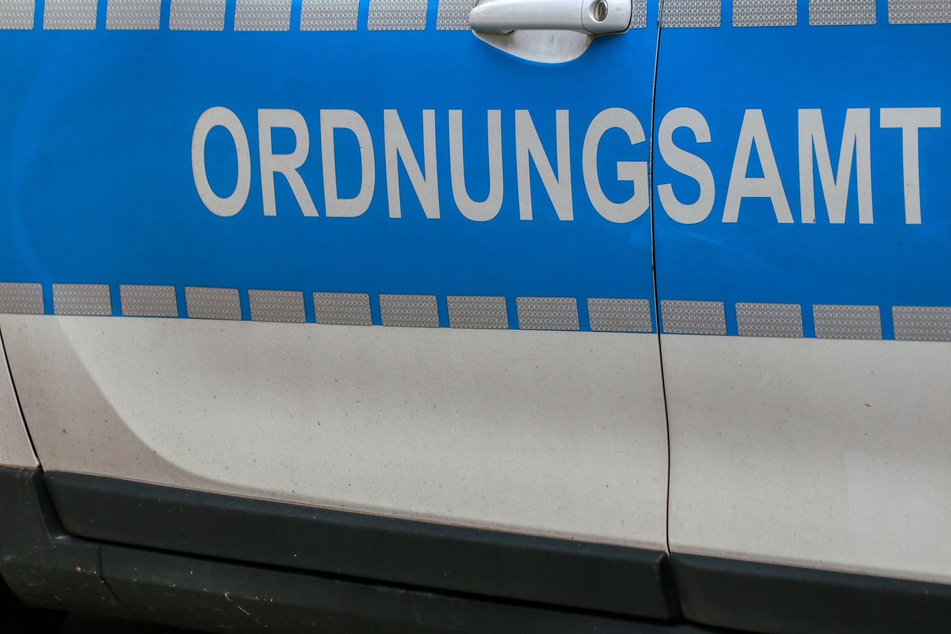 Seitenansicht der Aufschrift "Ordnungsamt" auf einem blauweißen Kraftfahrzeug eines Ordnungsamts